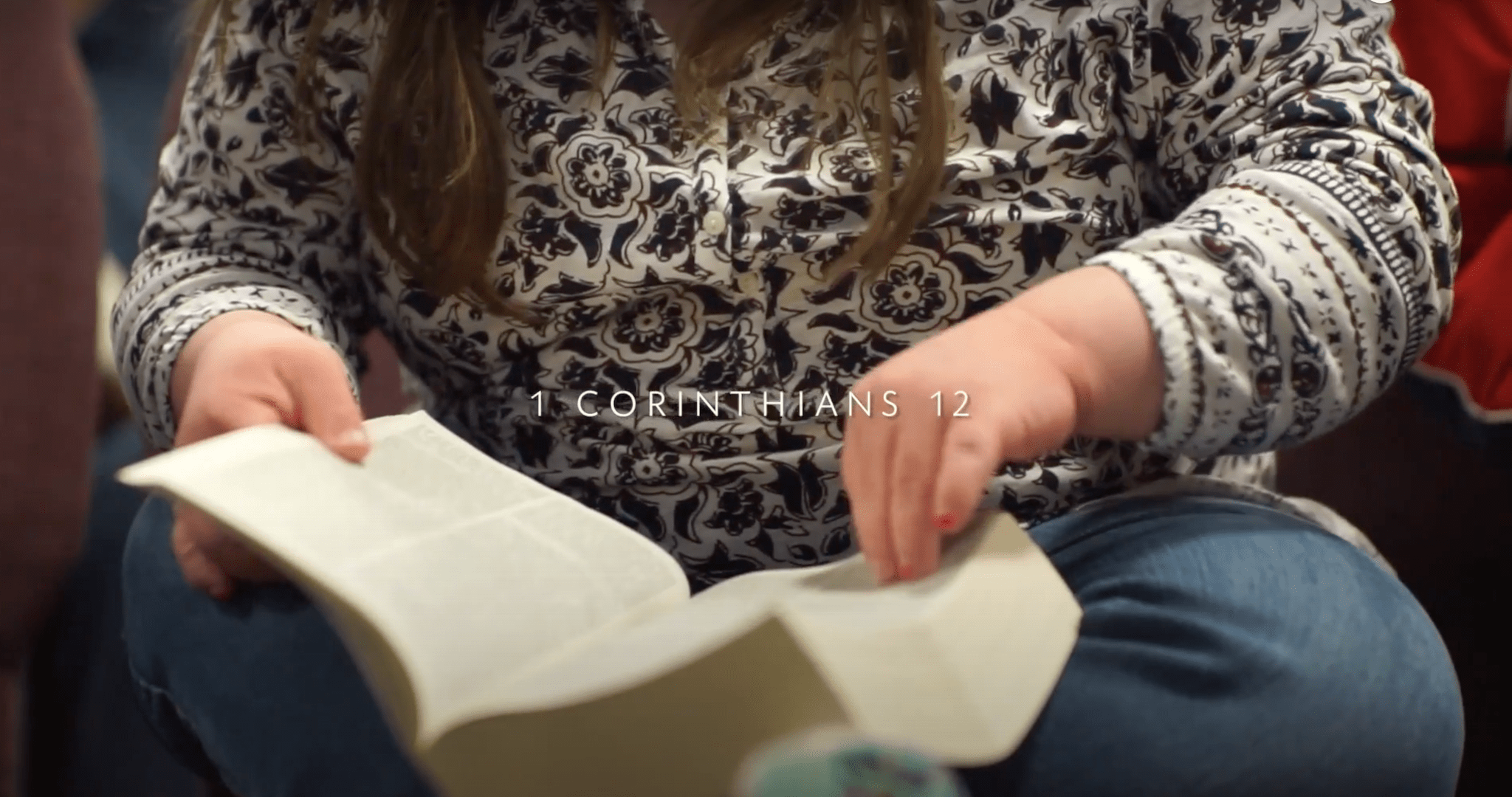 woman reading a bible with text that reads 1 Corinthians 12