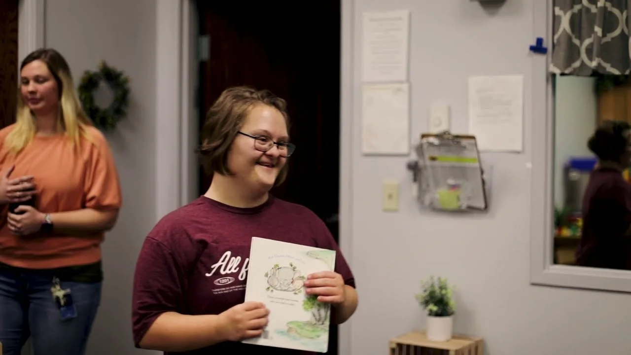 woman with down syndrome holding a book