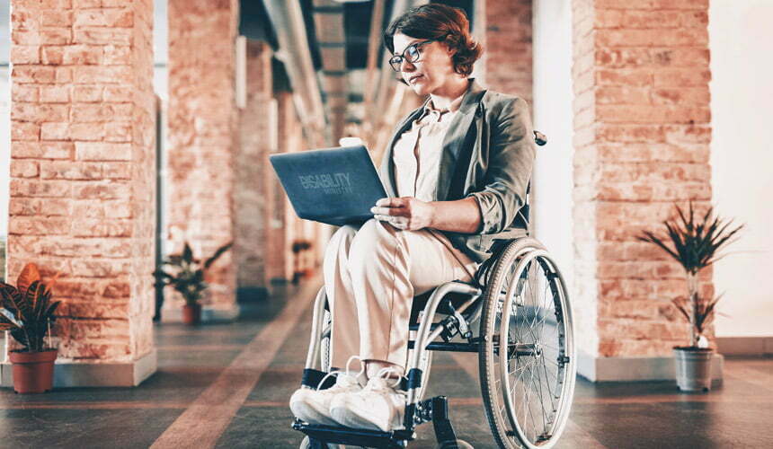 a person with a wheelchair sitting in a brick office building
