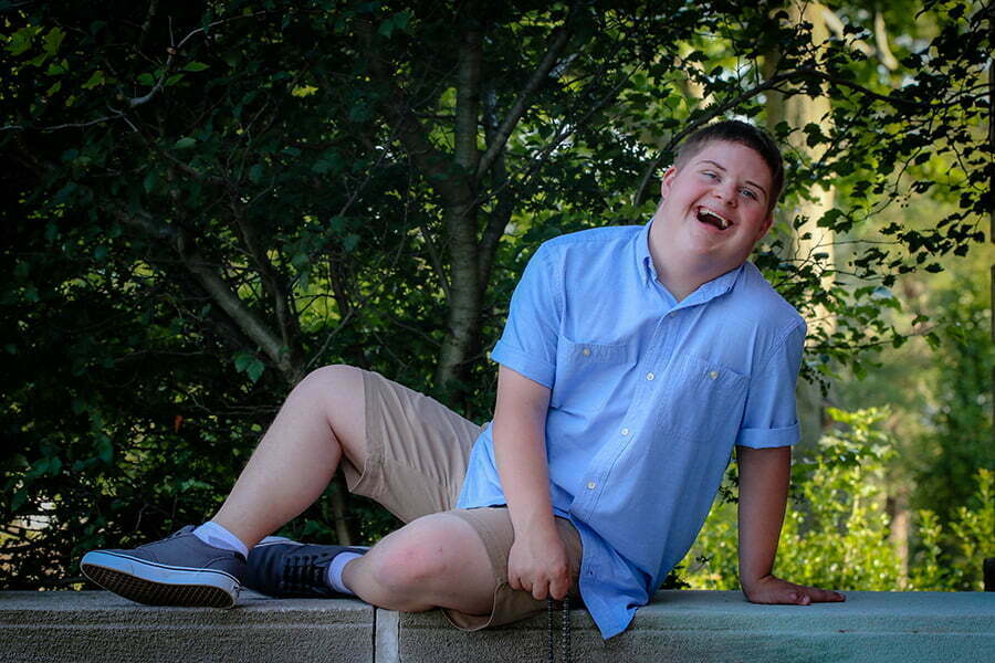 a man with Down syndrome sitting on a bench posing for the camera