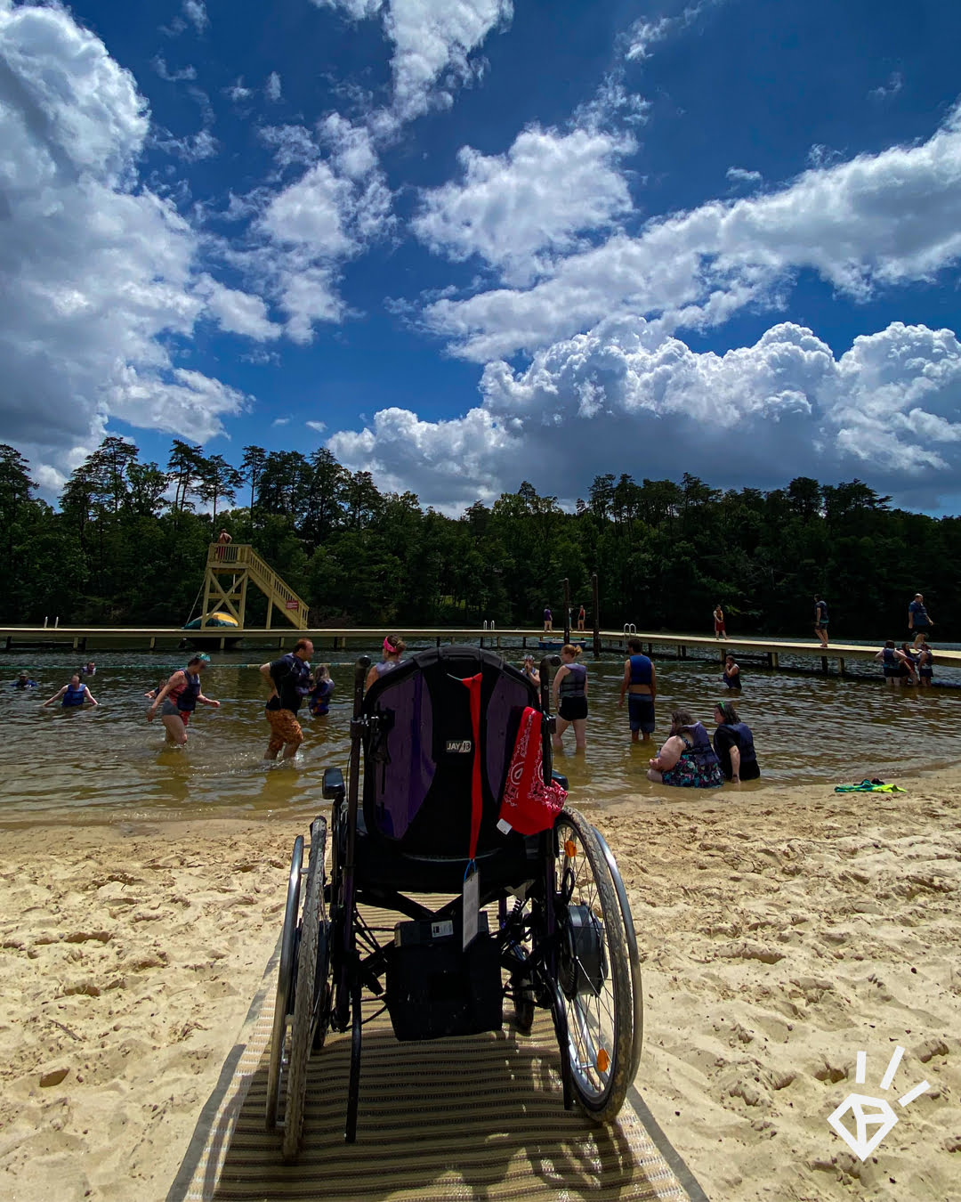 An empty wheelchair at the end of a ramp extended the length of a beach to the water.