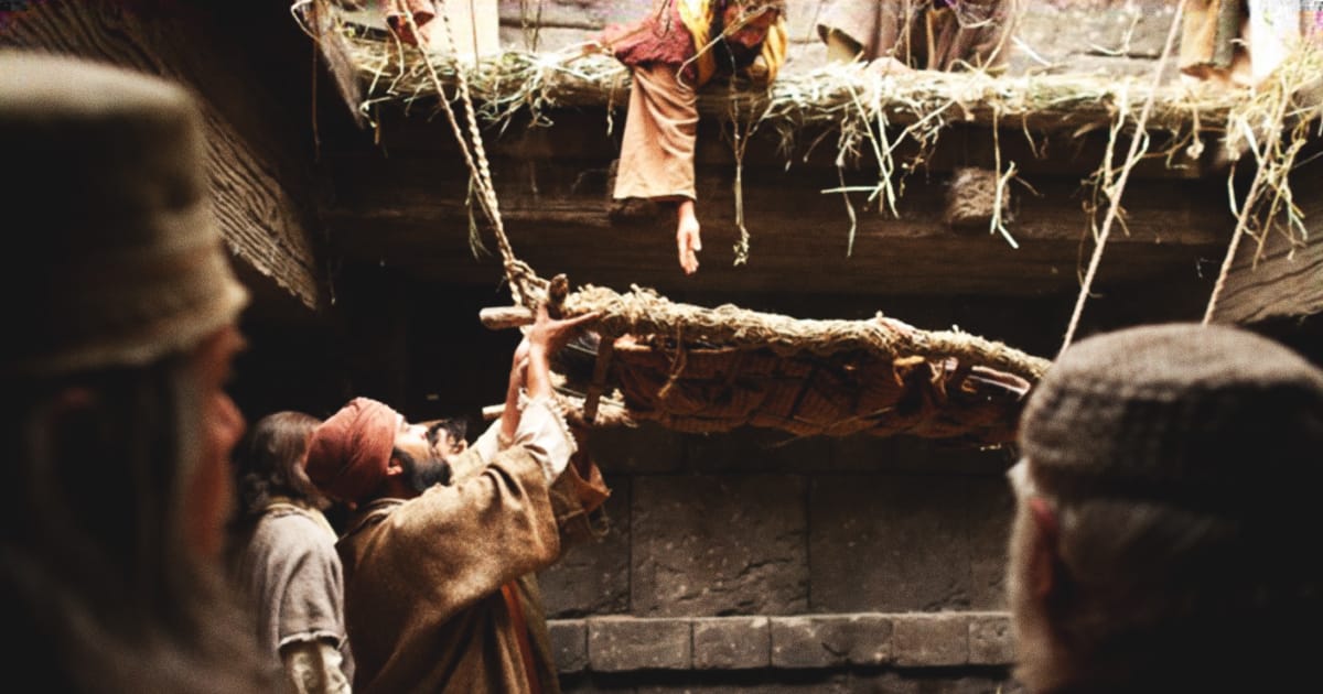 People lower a man through a roof to meet Jesus