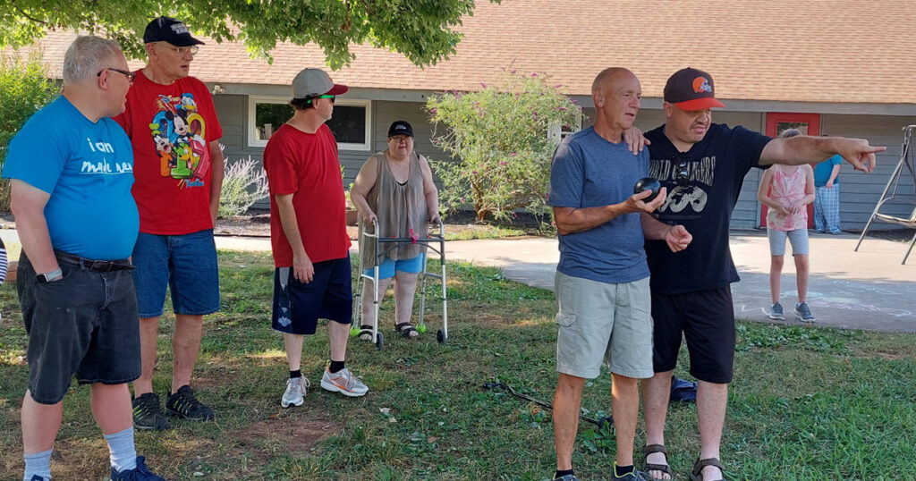 A group of people fellowshipping outside during the summer.