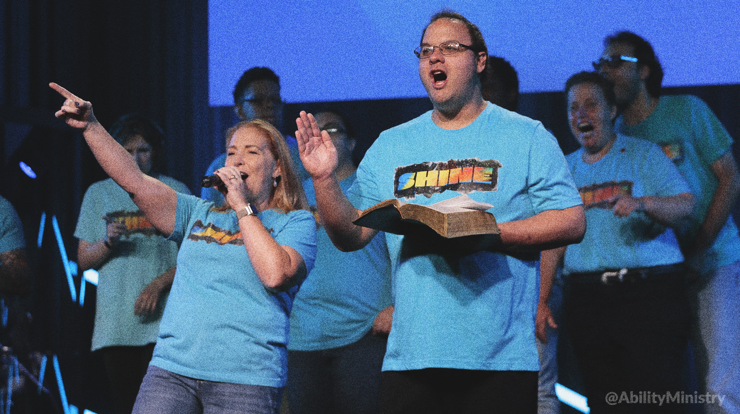 A group of men and women worshipping on stage together
